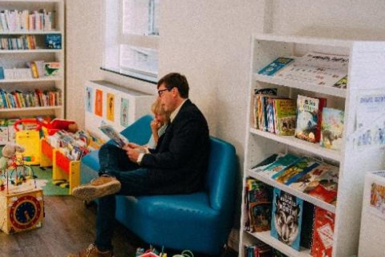 Aman reading to a child in Norwood library