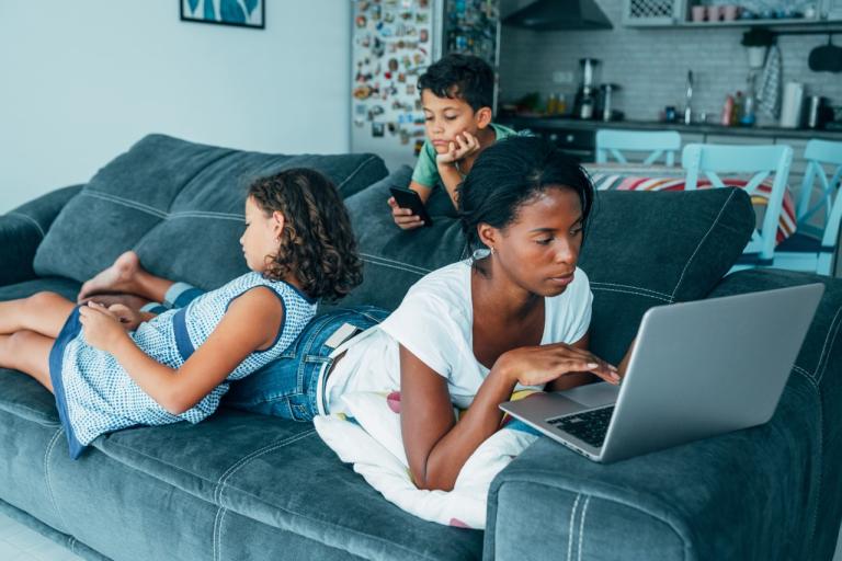 Mother laying on a sofa with her two children