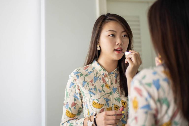 Teenager putting make-up looking on in mirror