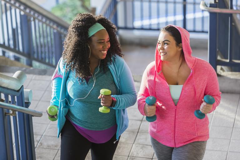 Two young women exercising on stairwell