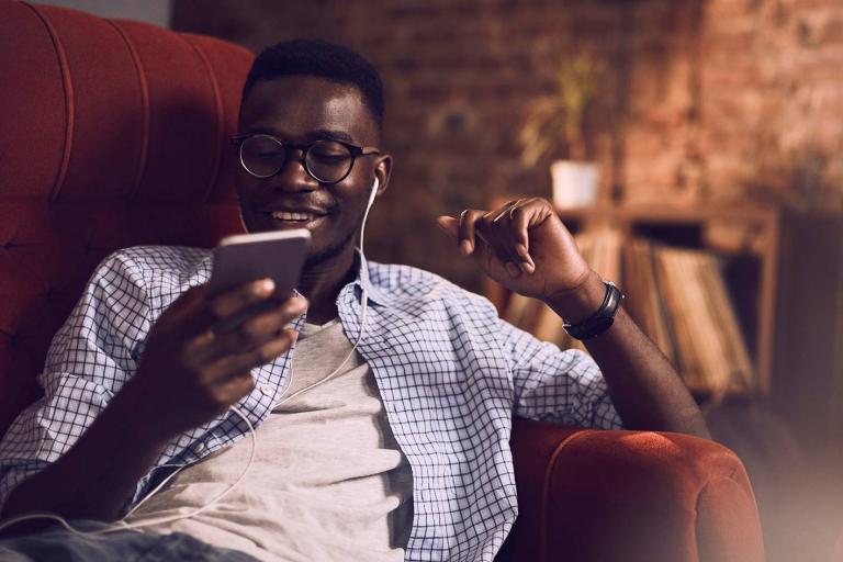 Young male smiling and relaxing on sofa