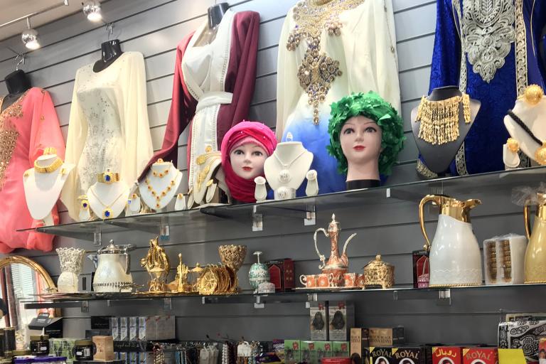 Women's clothes, wigs and jewellery on display in a shop
