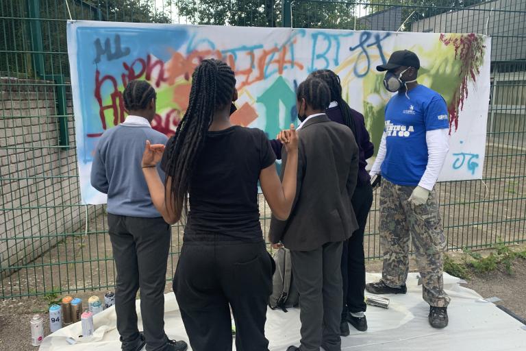 Group of children looking at a piece of painting 