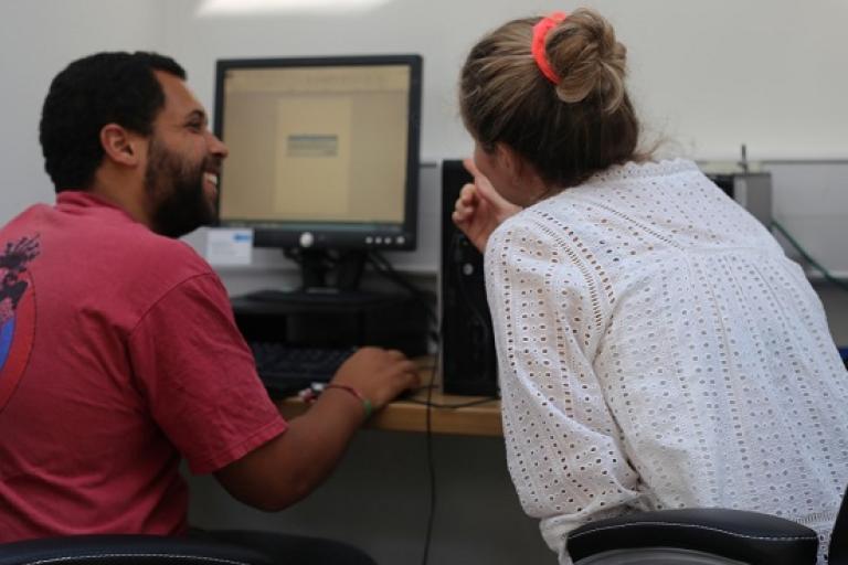 Two people work on computer