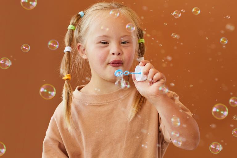 Happy girl blowing bubbles