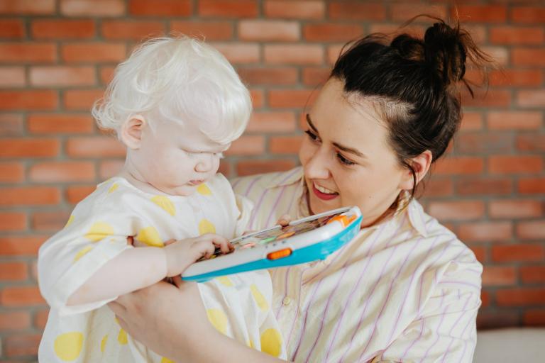 Woman holding child playing with toy