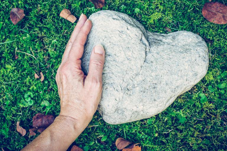 Hand on heart shaped stone