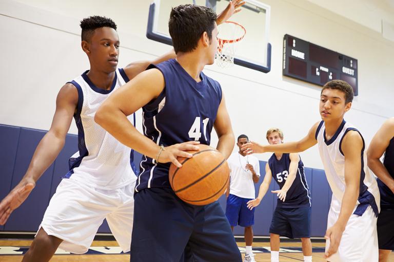 Teenagers playing indoor basketball