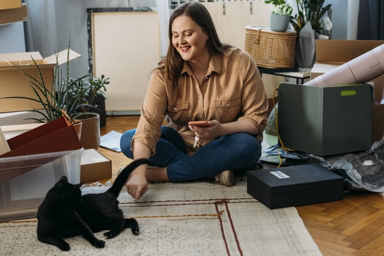 Woman sitting on floor with black cat
