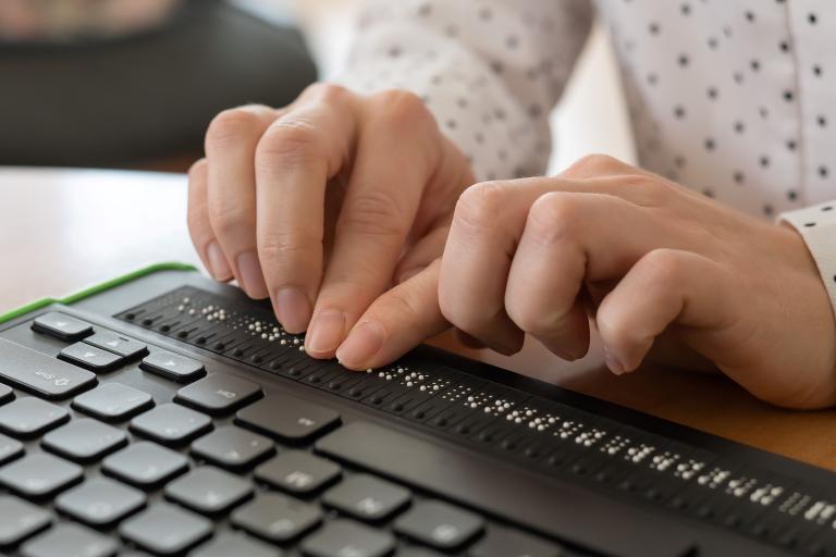 Individual using assitive technology (braille board)