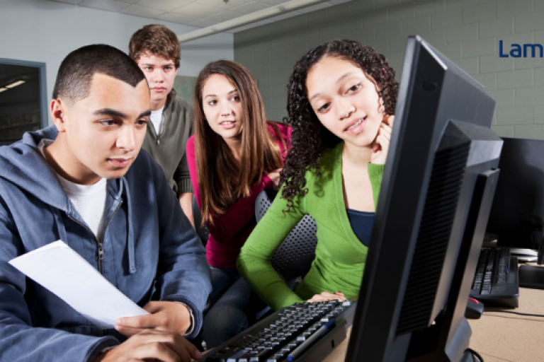 Young people sit around computer