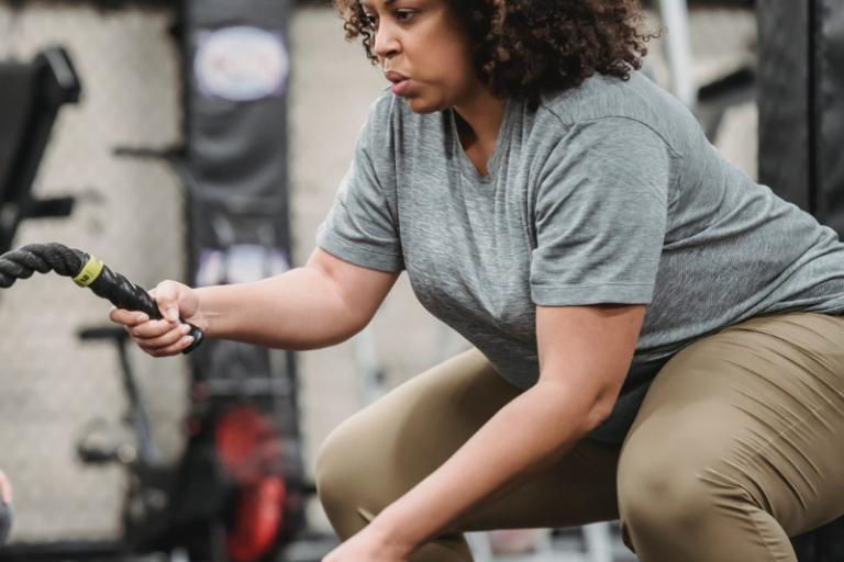 Woman exercising using ropes in a gym
