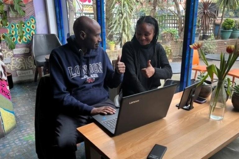 Man and woman sit at laptop and smile