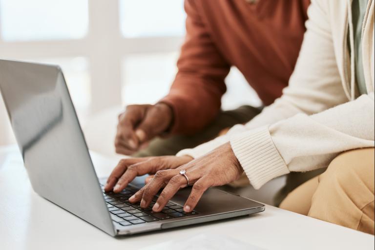 A lady typing on a laptop 