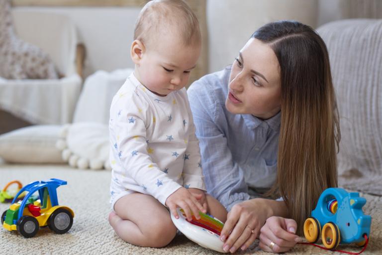 Woman lying on floor talking with baby