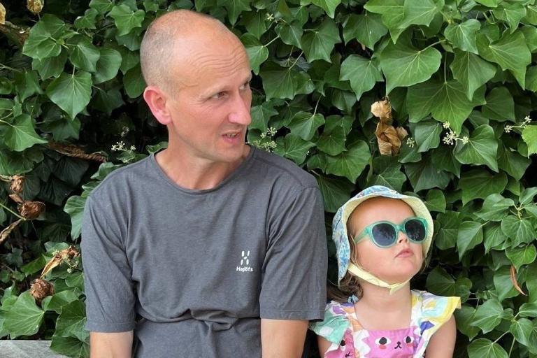 David sitting on a wall with a child