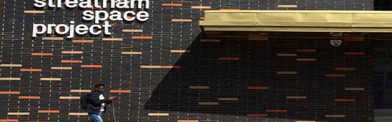 Male walking past the outside of Streatham Space Project building 