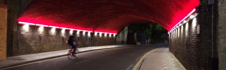 Person riding through lit up tunnel