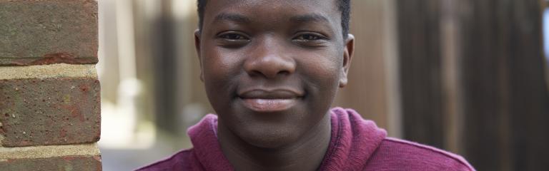 Happy teenager leaning against wall