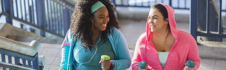 Two young women exercising on stairwell