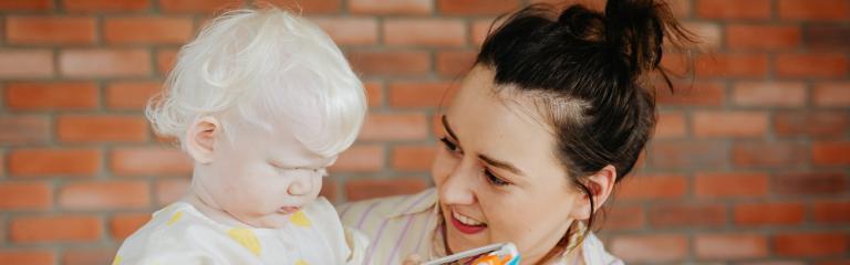 Woman holding child playing with toy