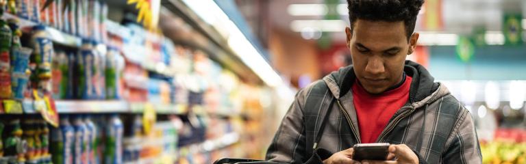 Man on phone shopping in a supermarket