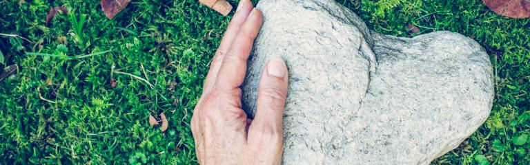 Hand on heart shaped stone