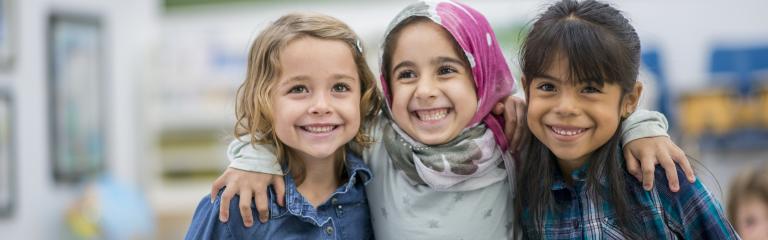 Three children hugging and laughing