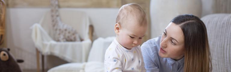 Woman lying on floor talking with baby