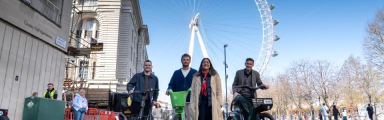 Cllr Rezina Chowdhury with dockless bike operators stood with ebikes in front of the London Eye