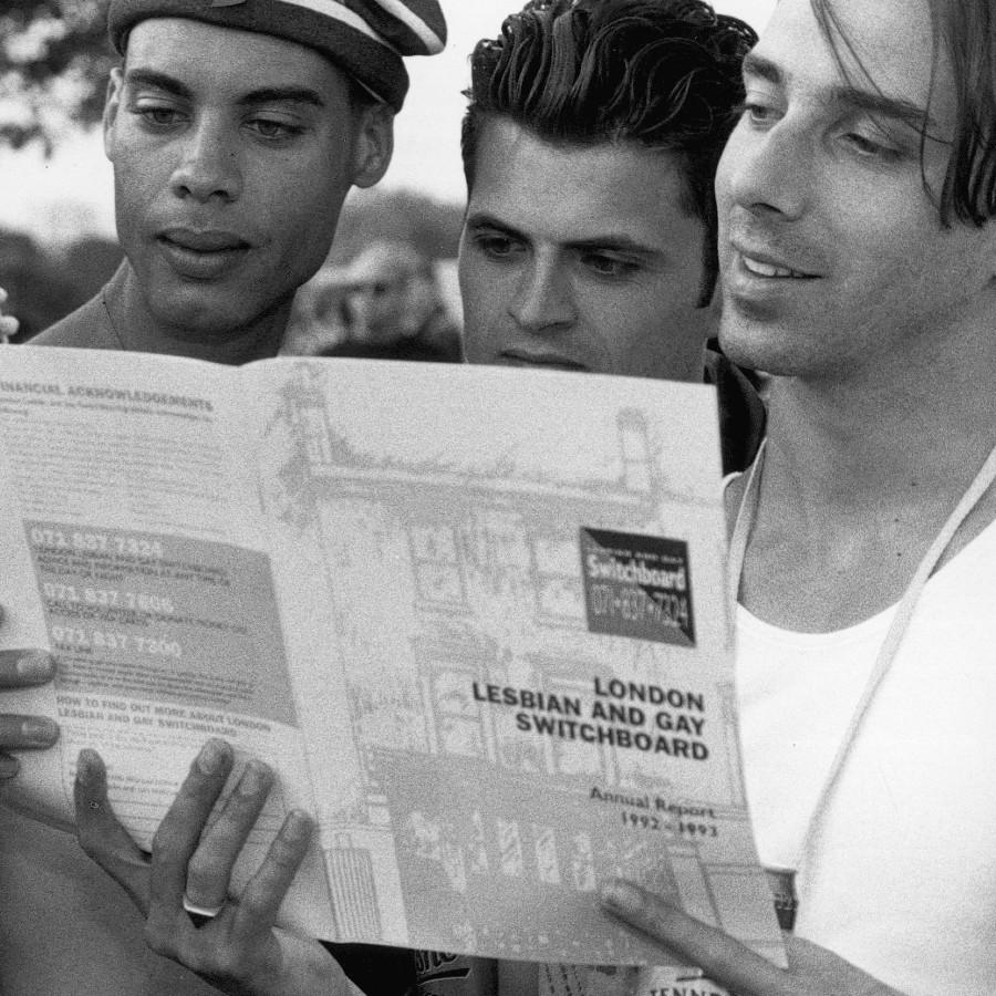 People reading an LGBTQ+ magazine