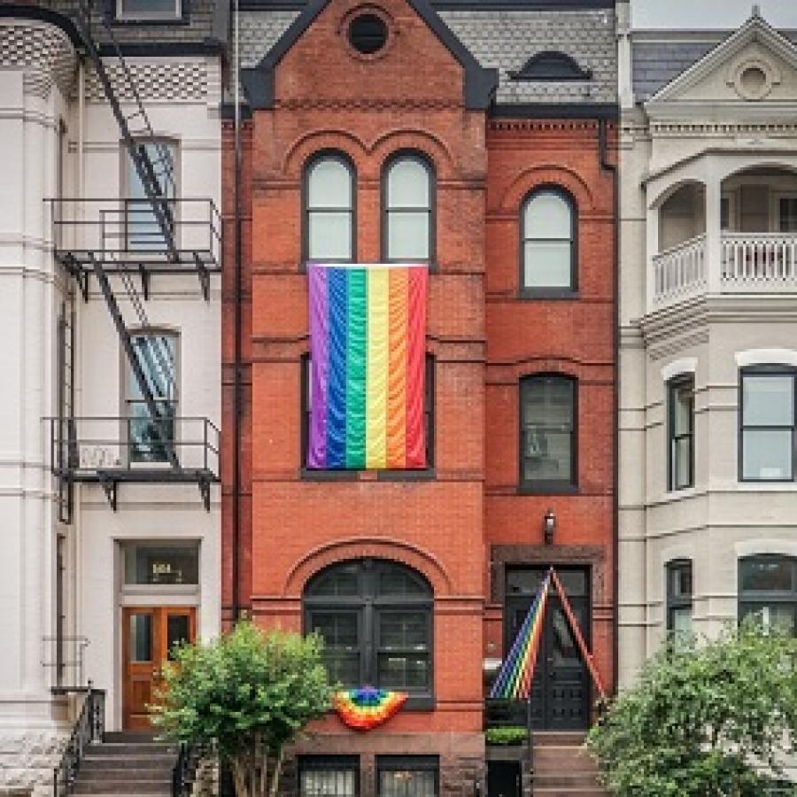 Lambeth Links logo & a redbrick house flying rainbow flags between two white 3-storey houses