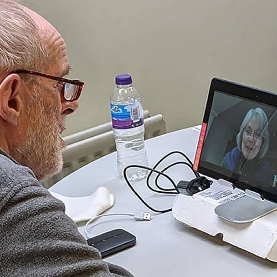 Older man using computer screen for conversation 