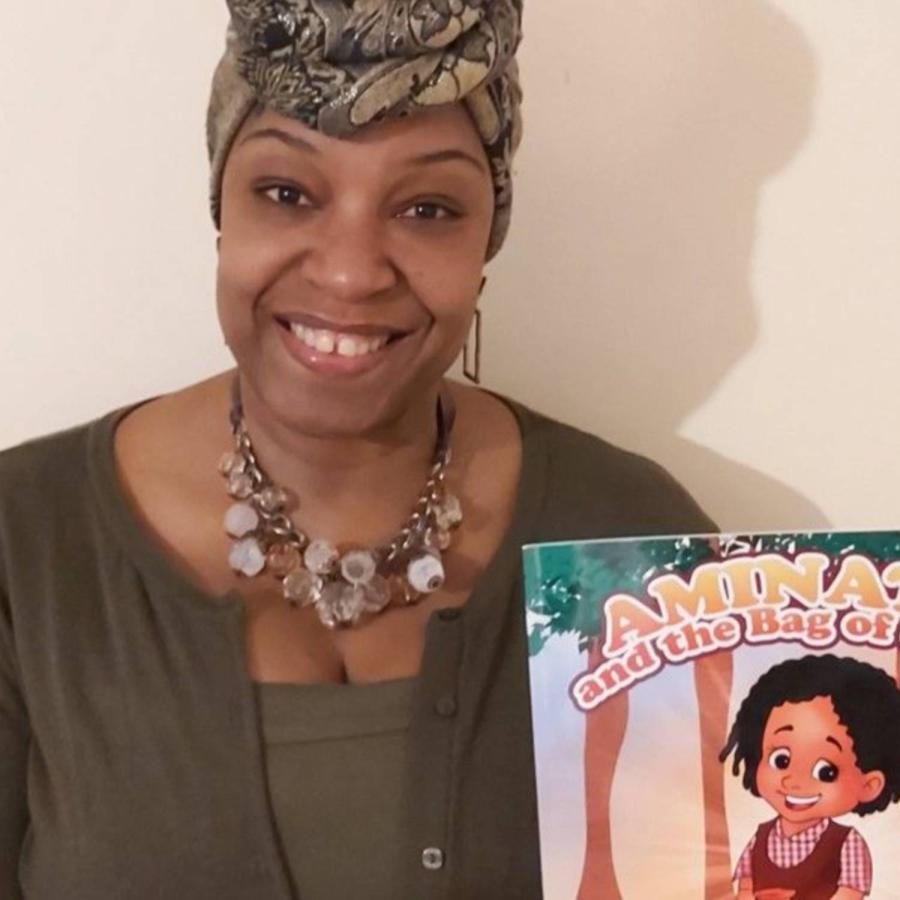 Sandra Moodie showing her book with a smile