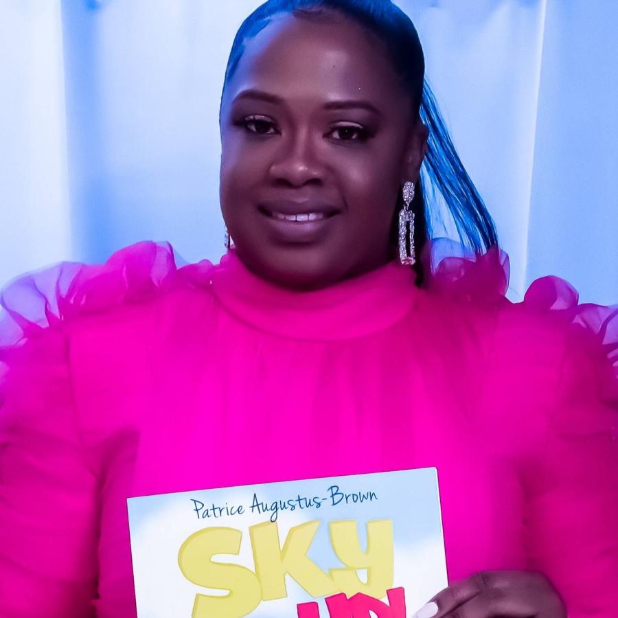 Patrice showing of her book and posing for the camera