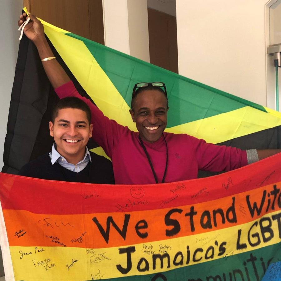 Two men raising rainbow flag