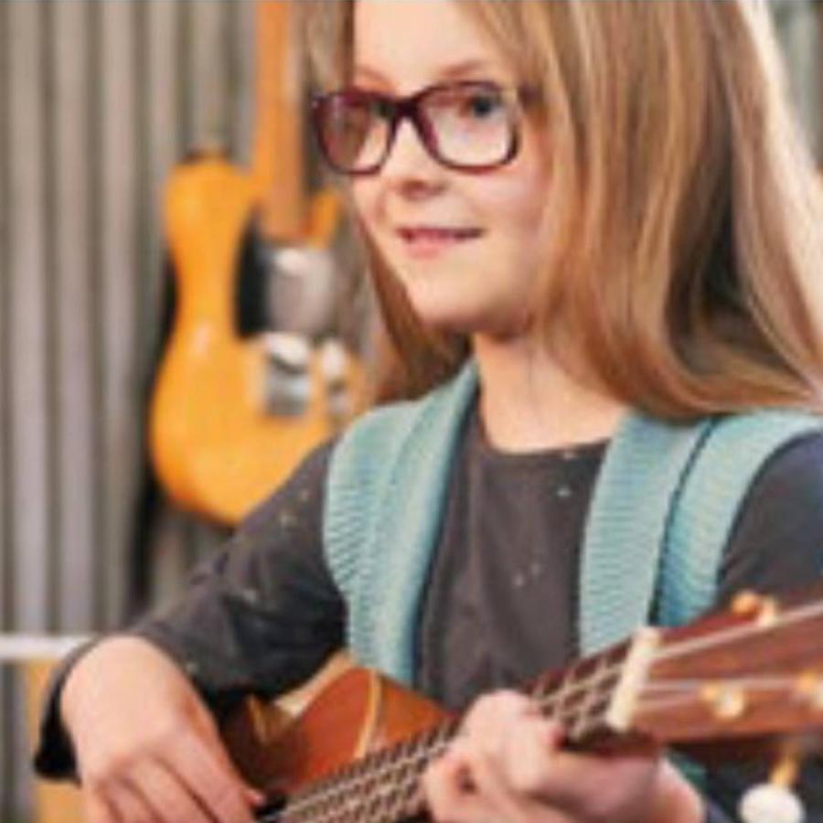 a snapshot of a young girl with a music instrument