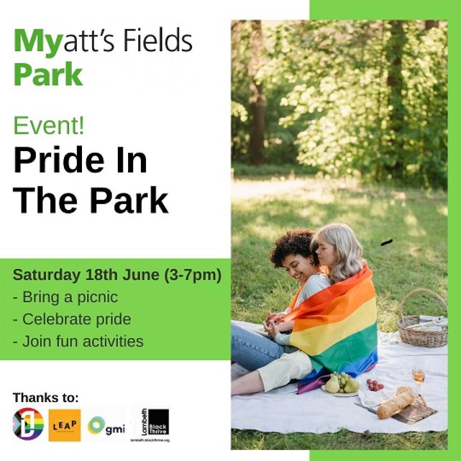 mother and toddler sitting on a picnic blanket wrapped in rainbow flag