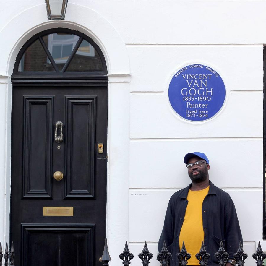 a man standing right infront of Van Gogh plague