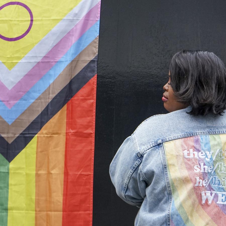 Smiling woman facing the pride flag