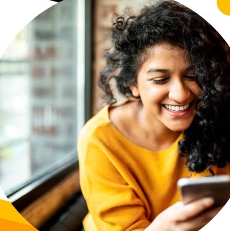 a lady cheerfully reading a message on her mobile phone