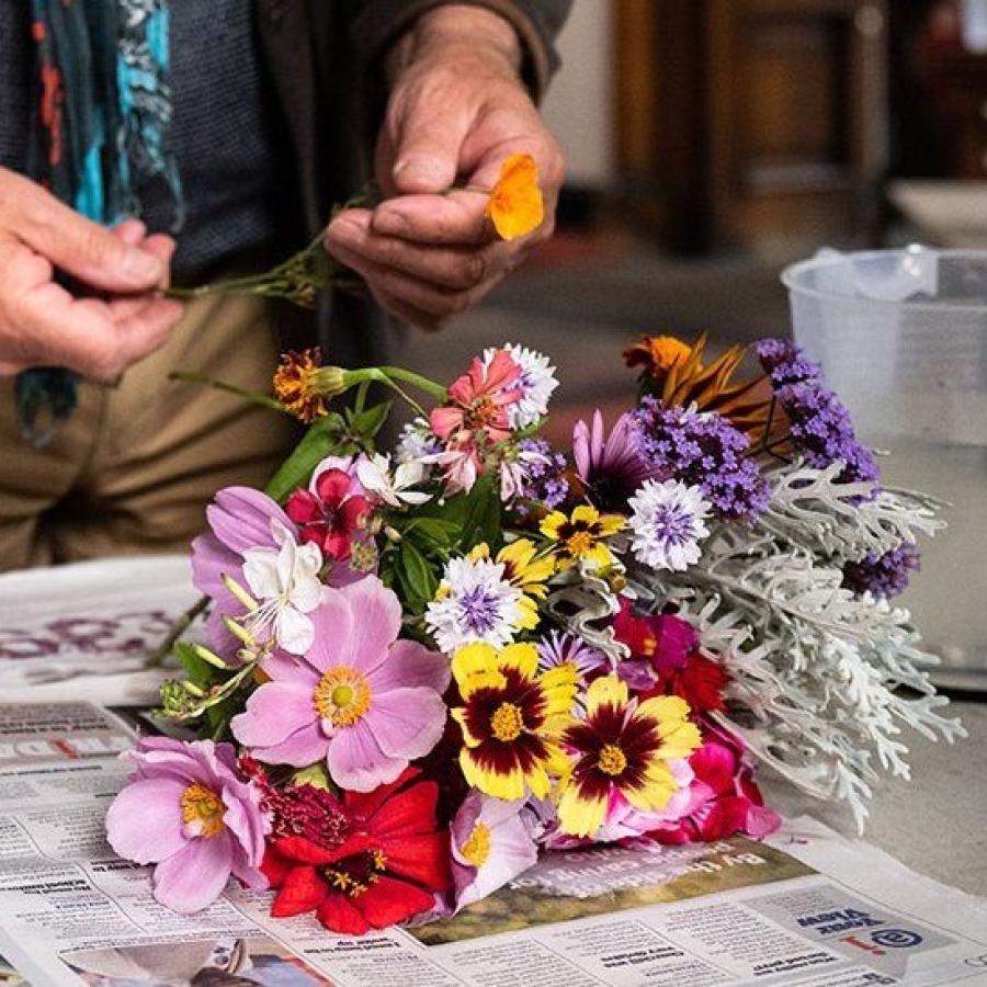 photo of someone making a bouquet of flowers on a table