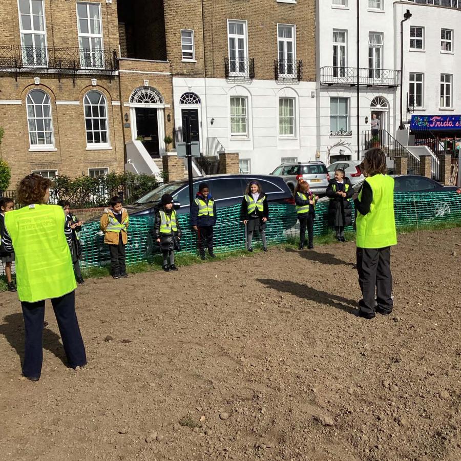 View of part of Kennington Green with school pupils planting out wildflower seeds
