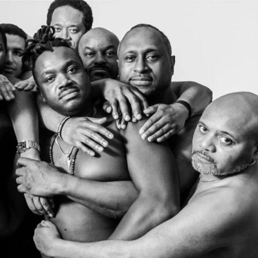 black & white photo of 6 men from Black Men's Consortium hugging