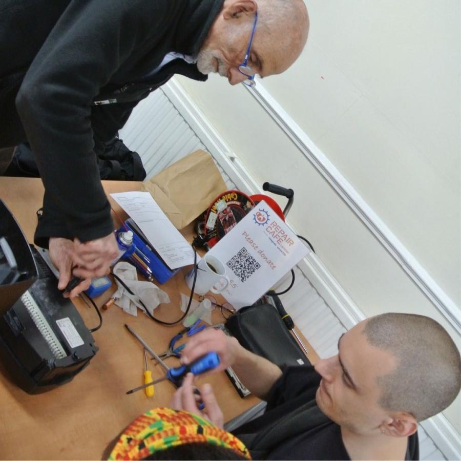 2 repaprers at Repairs cafe fixing a paper shredder