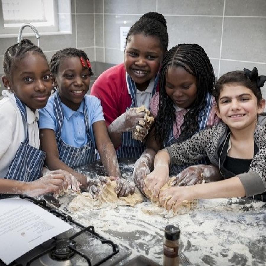 Volunteer xooking mentor at Baytree centre teaching children to make dough