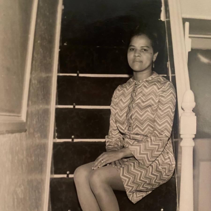 A beautiful lady sitting on a stairway, posing for the camera