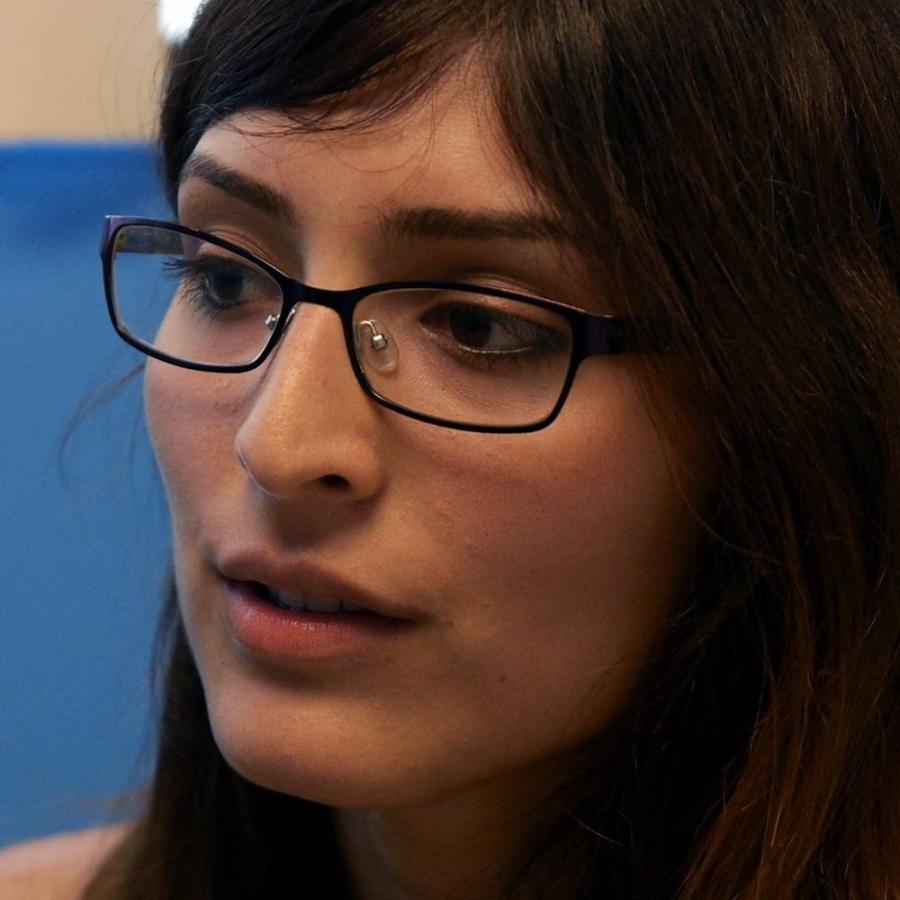 A lady discussing something with someone behind the scene