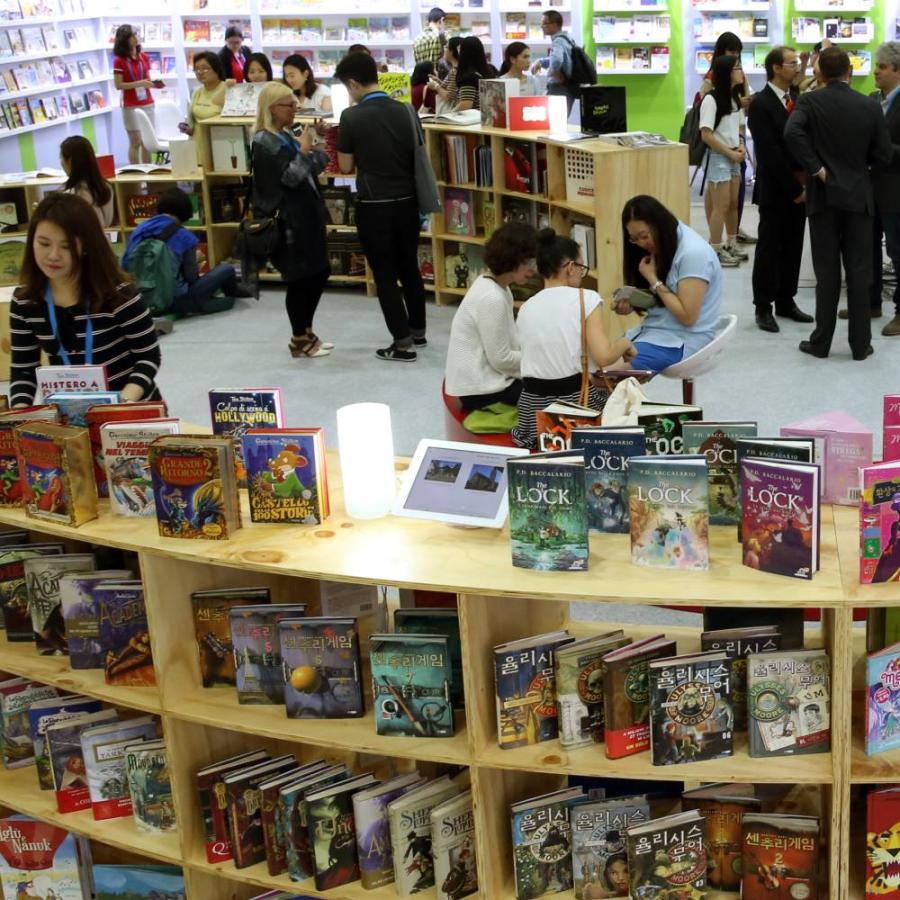 Various people gathered around books in a library