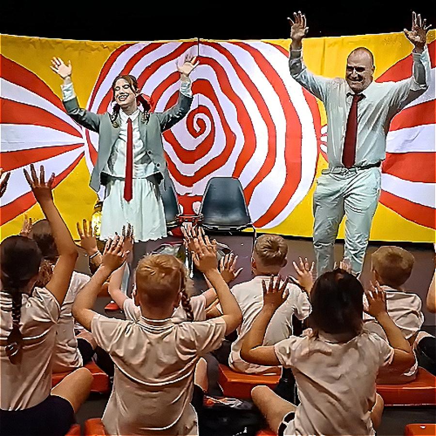 Actors lead children in an energetic, colourful theatrical performance